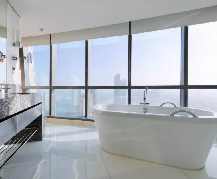 Salle de bains de luxe avec baignoire autonome près des fenêtres dans un gratte-ciel