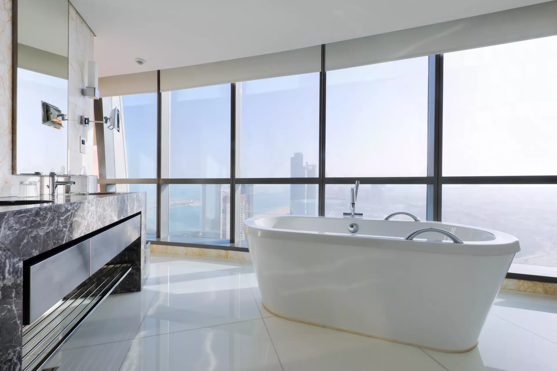 Salle de bains de luxe avec baignoire autonome près des fenêtres dans un gratte-ciel
