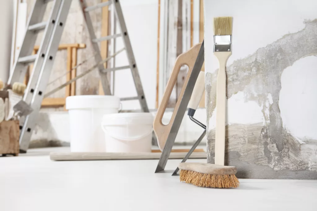 outils de maçon, de plâtrier ou de peintre en bâtiment sur un sol blanc avec des seaux dans une rénovation